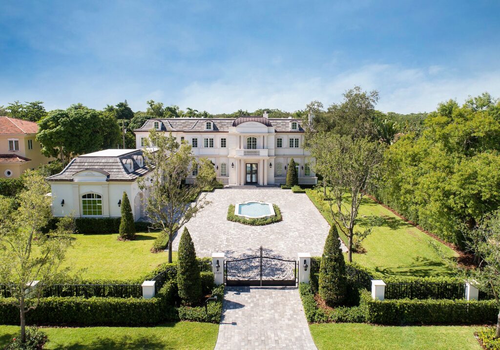 French manor-inspired Pinecrest FL estate on a large lot with courtyard in front